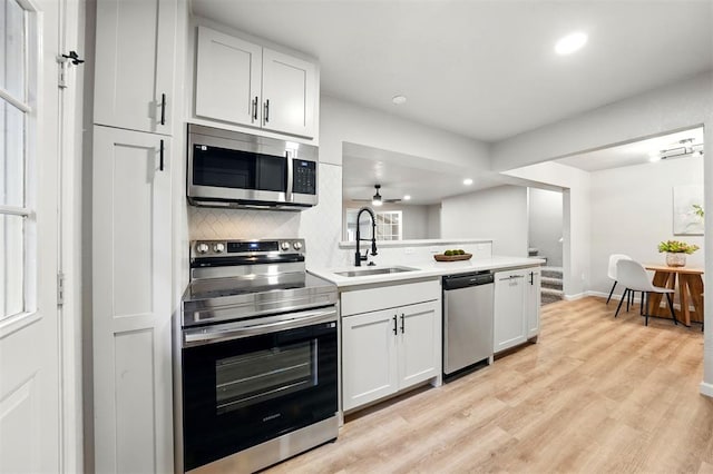 1731 Carlisle Rd, The Village, OK 73120 - kitchen with appliances with stainless steel finishes, a sink, recessed lighting, decorative backsplash, and a peninsula