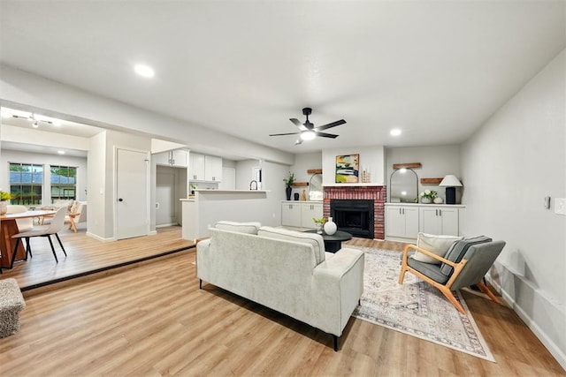 1731 Carlisle Rd, The Village, OK 73120 - living area featuring light wood-style flooring, a fireplace, a ceiling fan, baseboards, and recessed lighting