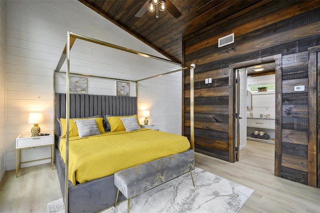 bedroom featuring wooden walls, wood finished floors, visible vents, vaulted ceiling, and wooden ceiling