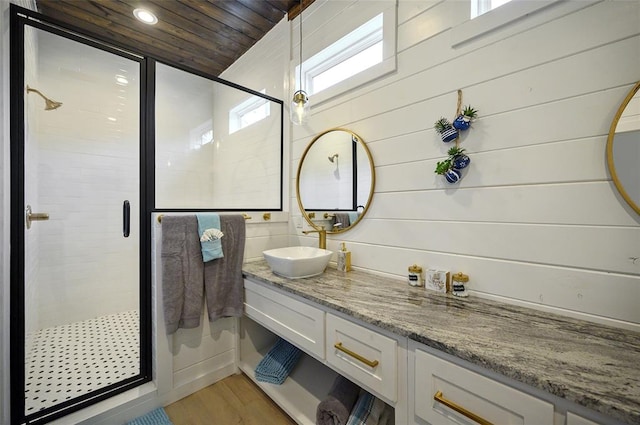 bathroom with vanity, wooden ceiling, wood finished floors, and a stall shower