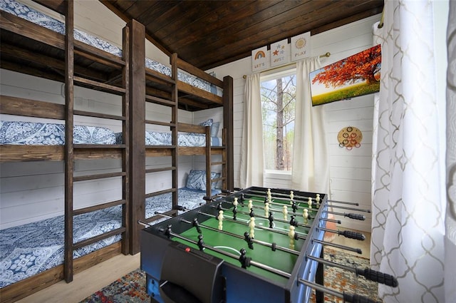 recreation room with vaulted ceiling, wood ceiling, wooden walls, and wood finished floors