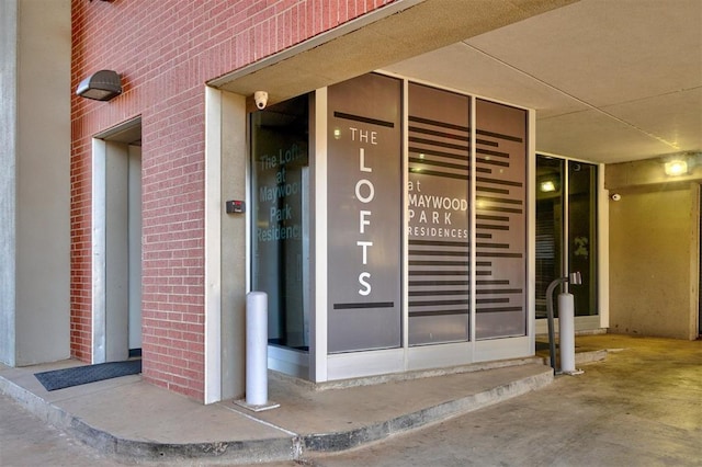 view of exterior entry with elevator and brick siding