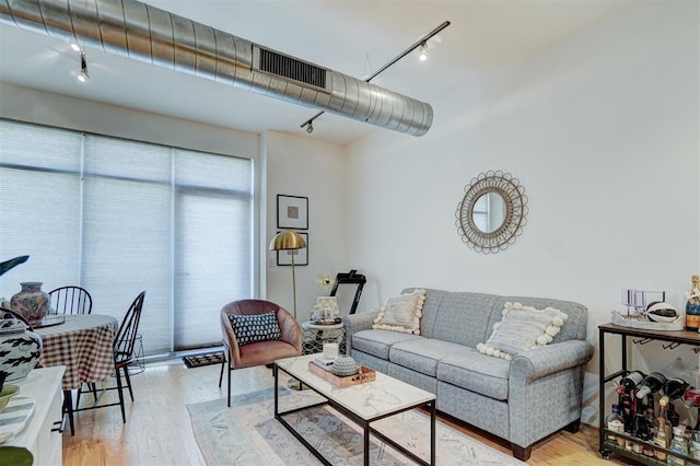 living area with visible vents, light wood-style floors, and track lighting