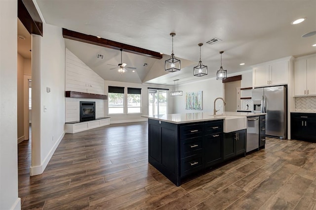 kitchen featuring a sink, stainless steel appliances, visible vents, and dark cabinetry