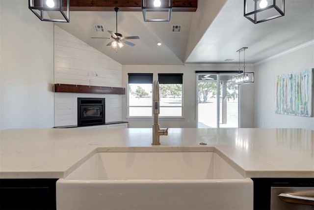 kitchen with visible vents, ornamental molding, a sink, open floor plan, and ceiling fan