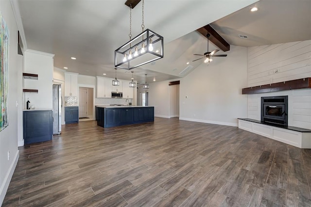 unfurnished living room with dark wood finished floors, lofted ceiling with beams, ceiling fan, and a sink