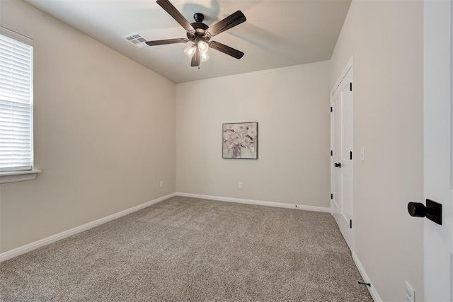 carpeted empty room featuring visible vents, ceiling fan, and baseboards