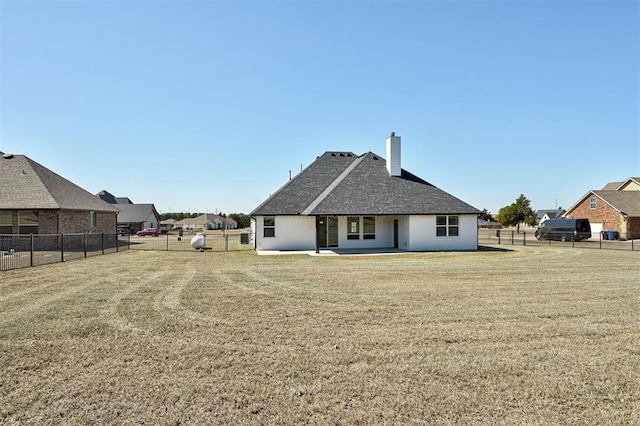 rear view of house featuring a patio area, a lawn, a chimney, and fence