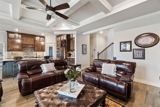 living area featuring baseboards, coffered ceiling, a ceiling fan, and light wood finished floors