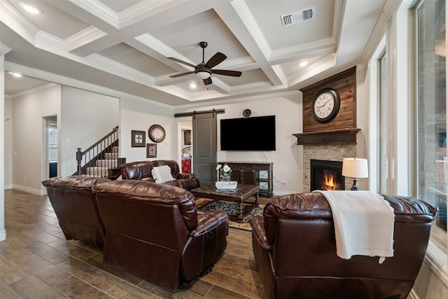 living room with visible vents, beam ceiling, coffered ceiling, a barn door, and ceiling fan