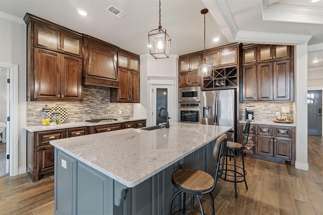 kitchen featuring a sink, appliances with stainless steel finishes, crown molding, and custom range hood