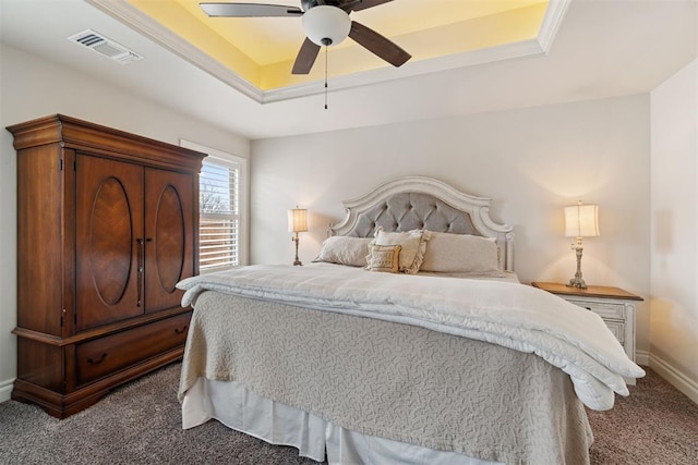 carpeted bedroom featuring visible vents, a raised ceiling, baseboards, and ceiling fan