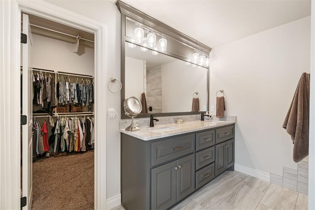 full bath with a sink, a walk in closet, and double vanity