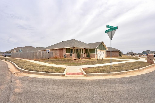 single story home with brick siding, fence, a garage, and driveway