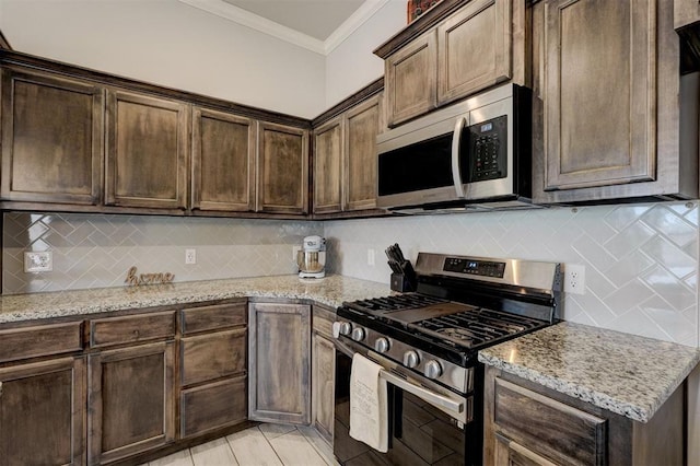 kitchen featuring dark brown cabinetry, appliances with stainless steel finishes, light stone countertops, and ornamental molding