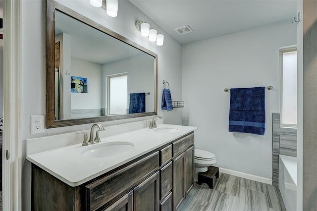 full bathroom with double vanity, visible vents, toilet, and a sink