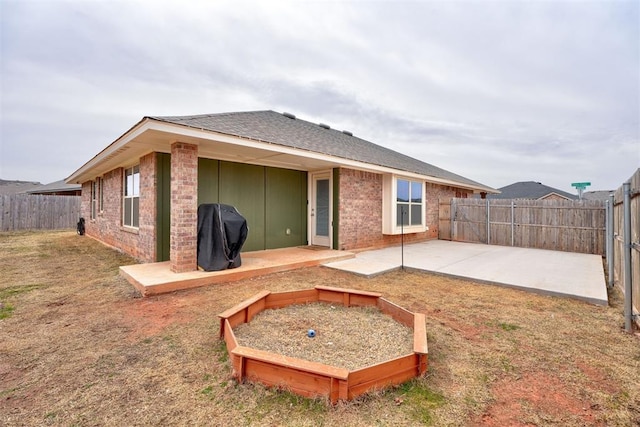 rear view of house with a patio area, brick siding, and a fenced backyard