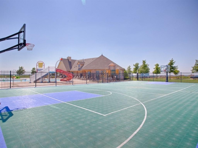 view of sport court with community basketball court, fence, and playground community