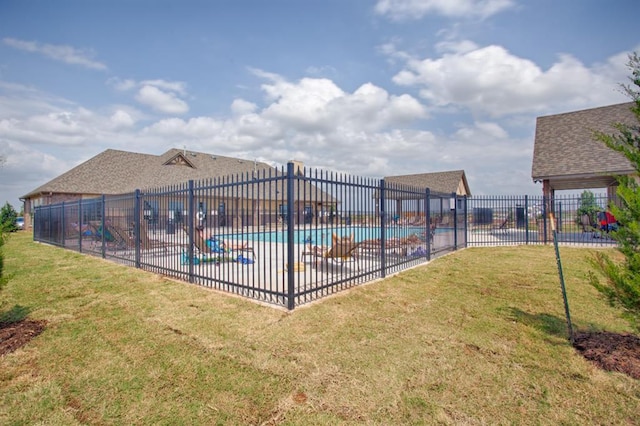 pool with a patio area, a yard, and fence