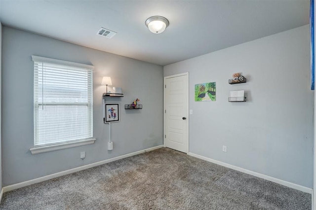 empty room featuring visible vents, baseboards, and carpet