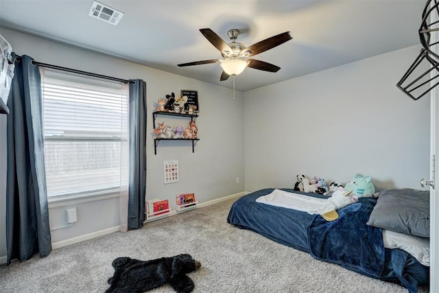 carpeted bedroom with visible vents, a ceiling fan, and baseboards