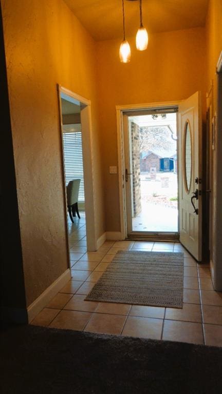 foyer entrance with light tile patterned flooring and baseboards