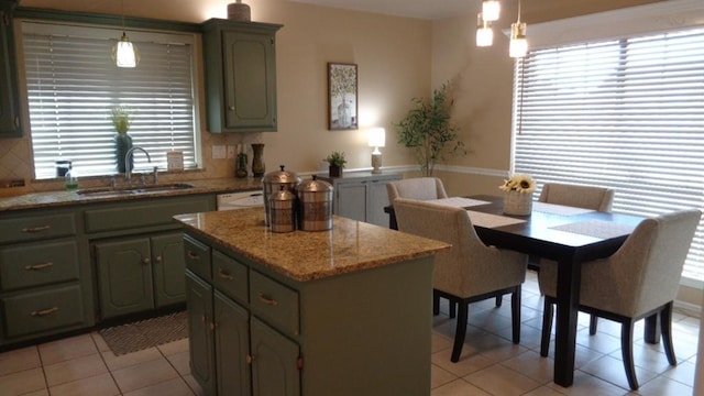 kitchen with a sink, plenty of natural light, a center island, and light tile patterned floors