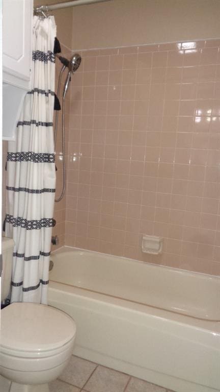 bathroom with tile patterned floors, toilet, and shower / bath combo