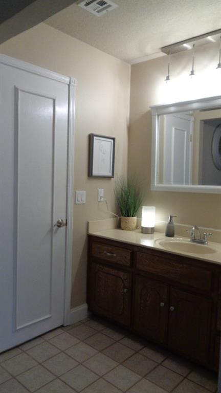 bathroom with tile patterned floors, visible vents, and vanity