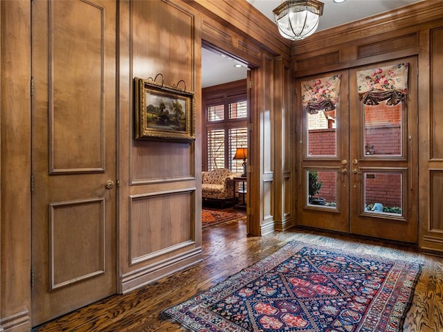 entrance foyer featuring wooden walls, french doors, and dark wood-style flooring