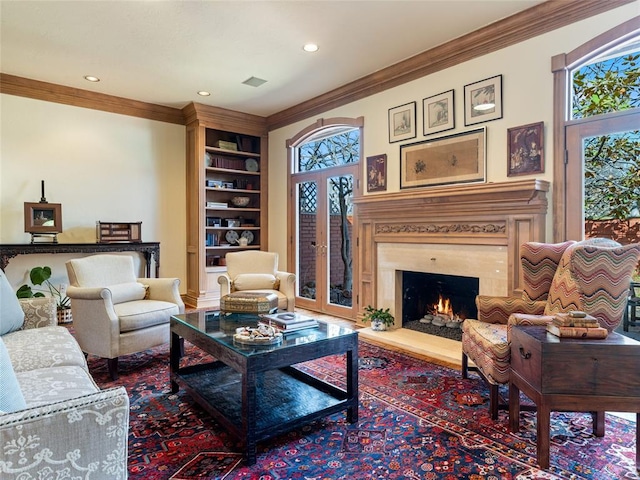 sitting room featuring a high end fireplace, visible vents, french doors, and ornamental molding