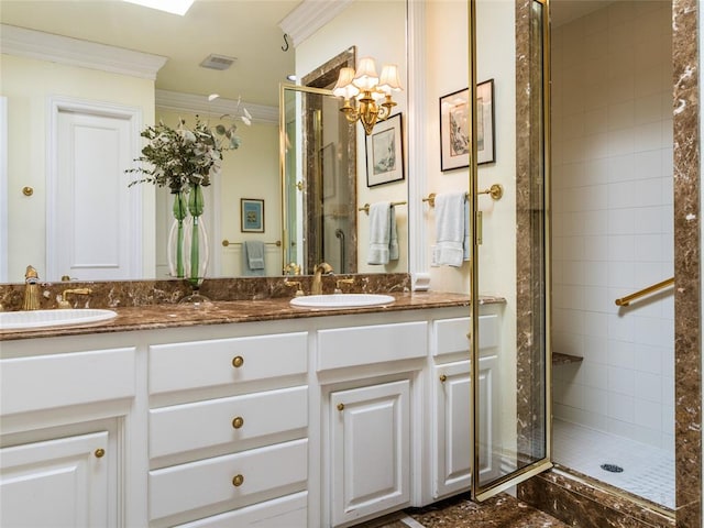 bathroom featuring a sink, double vanity, a stall shower, and crown molding