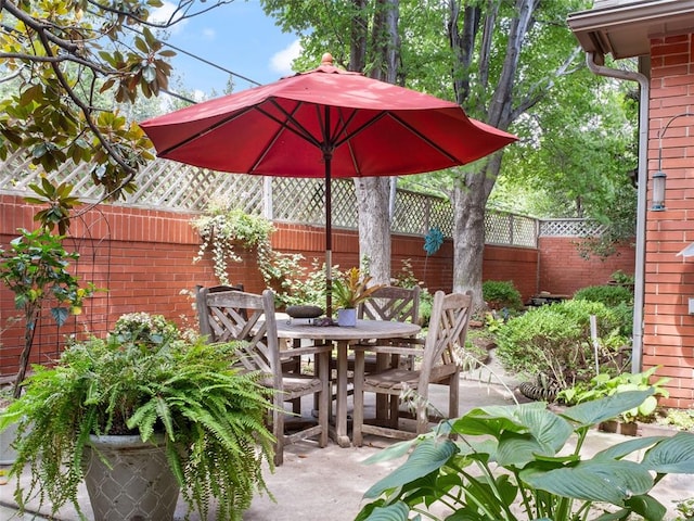 view of patio with outdoor dining space and fence