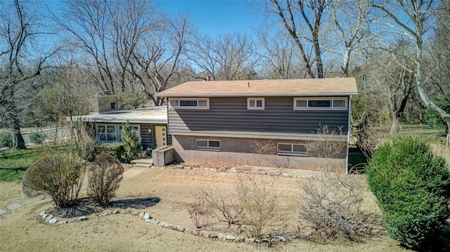 rear view of property with brick siding