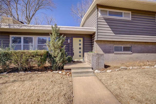 view of exterior entry featuring brick siding