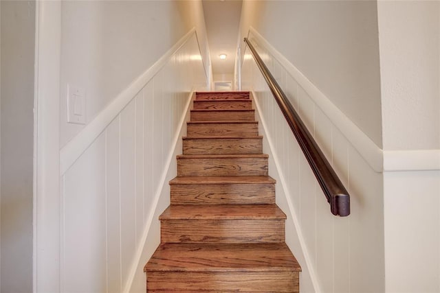 stairway featuring a decorative wall