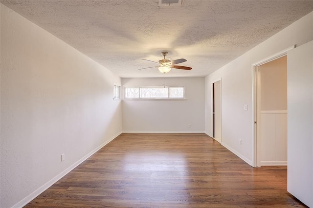 empty room with baseboards, a textured ceiling, a ceiling fan, and wood finished floors