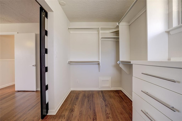 walk in closet with wood finished floors