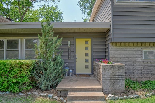 entrance to property featuring brick siding