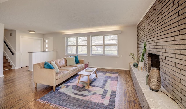 living room with baseboards, a textured ceiling, and wood finished floors