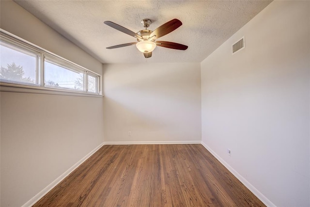 unfurnished room featuring ceiling fan, a textured ceiling, visible vents, and wood finished floors