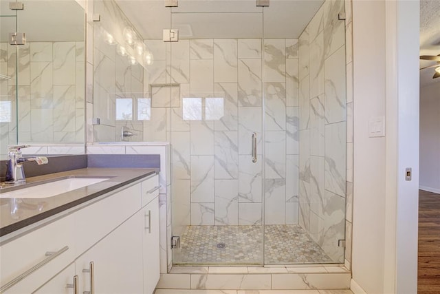 bathroom with vanity, baseboards, marble finish floor, and a stall shower