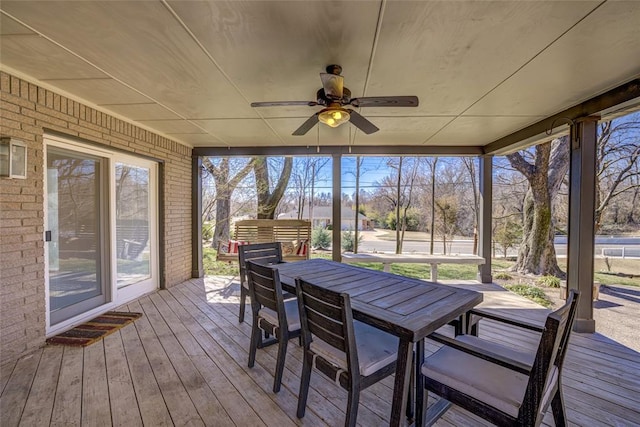 sunroom / solarium with a ceiling fan and outdoor dining area