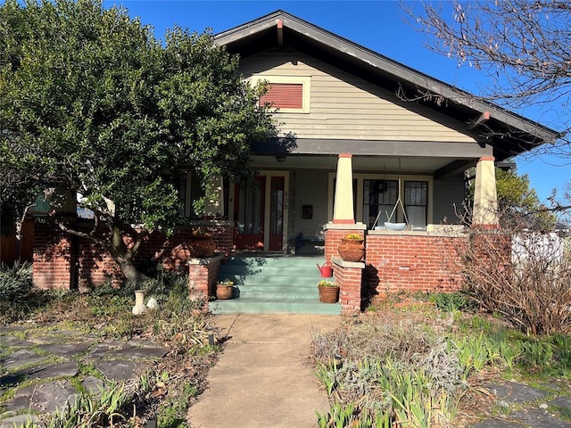 view of front of house with brick siding and covered porch