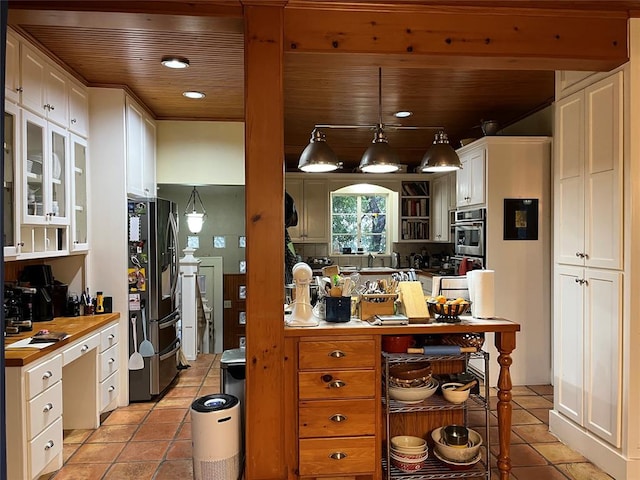 kitchen with light tile patterned floors, white cabinets, wood ceiling, and stainless steel fridge with ice dispenser