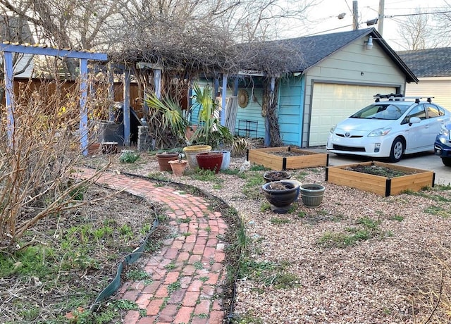 exterior space with a garden, fence, and a garage