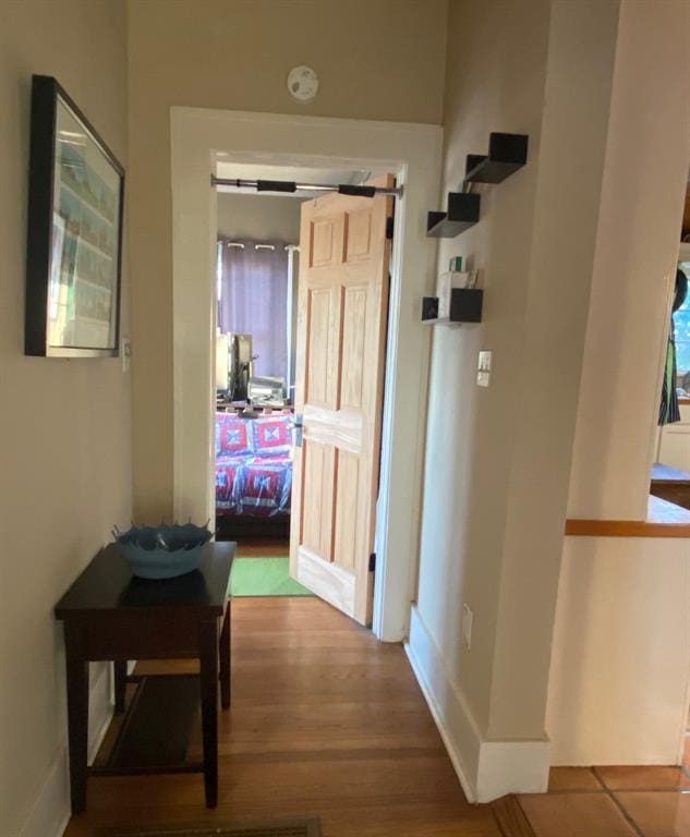 hallway featuring baseboards and wood finished floors