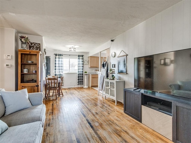 living room featuring light wood-type flooring and a textured ceiling