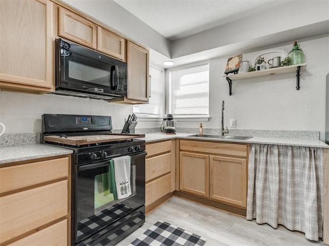 kitchen featuring light brown cabinets, a sink, black appliances, light countertops, and light wood-style floors