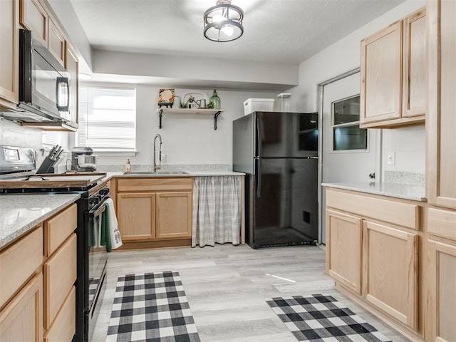 kitchen featuring black appliances, light brown cabinets, a sink, open shelves, and light wood finished floors